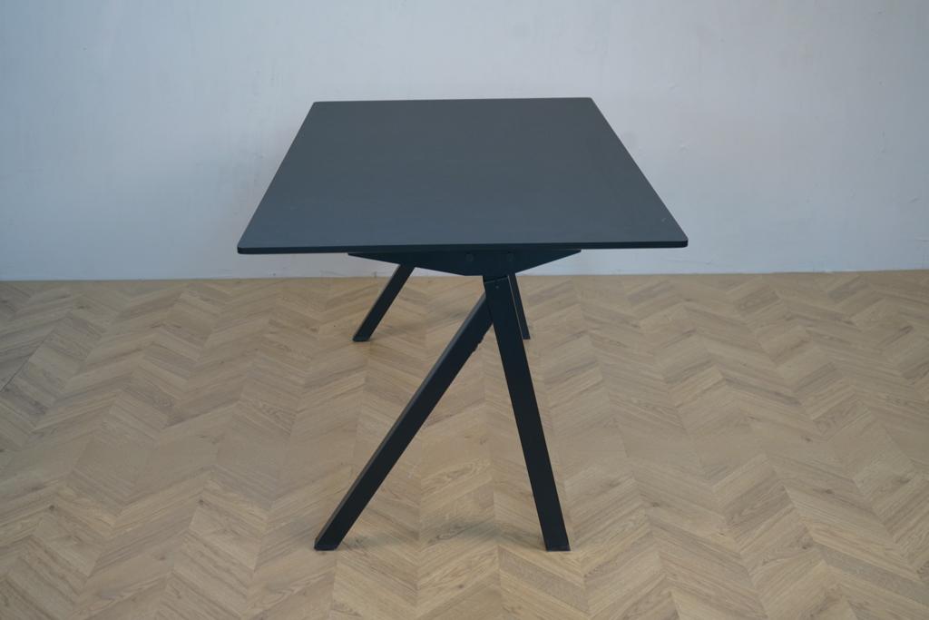 Arnehus hæve-sænkebord i sort linoleum set fra siden med elegant understel og affasede kanter